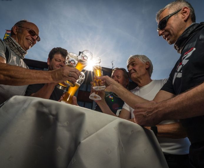 Anstoßende Gruppe mit Bier nach Motorradurlaub